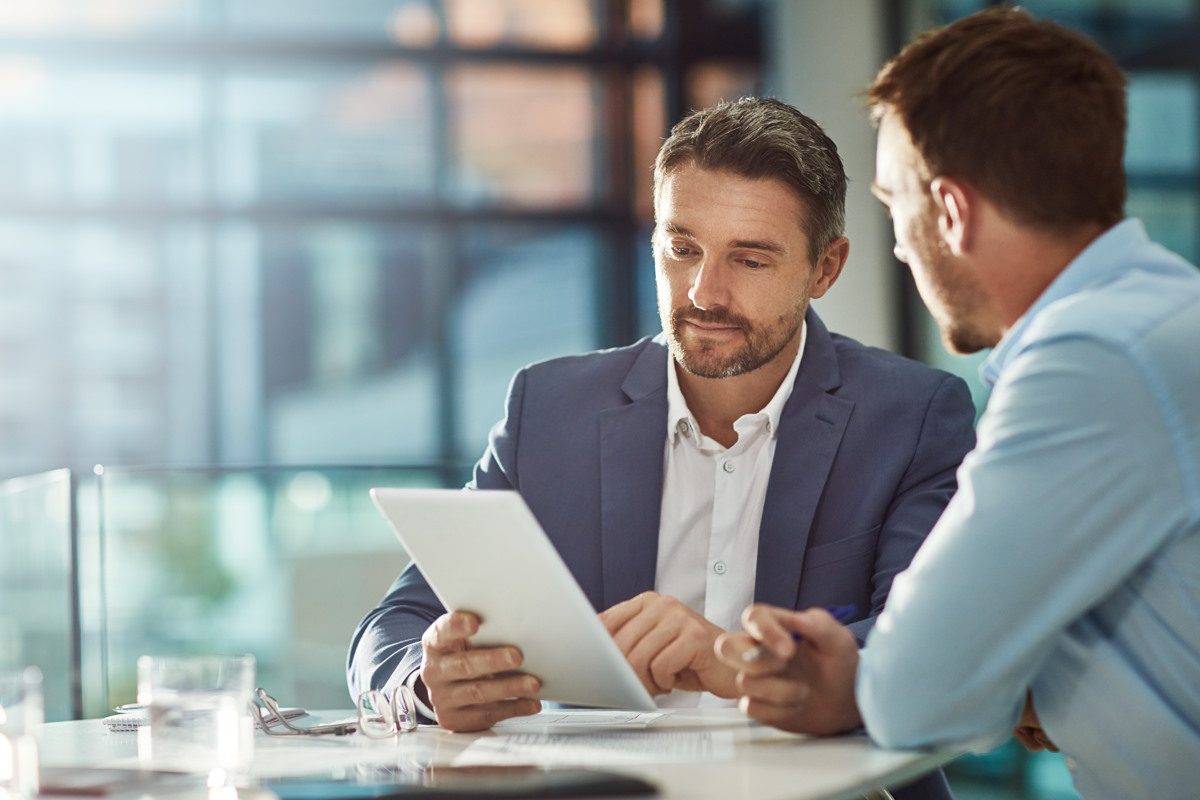 Zwei Berater besprechen die Unternehmensfinanzen am Tablet - FINACOACH - Firmenkunden - Finanzpartner für B2B